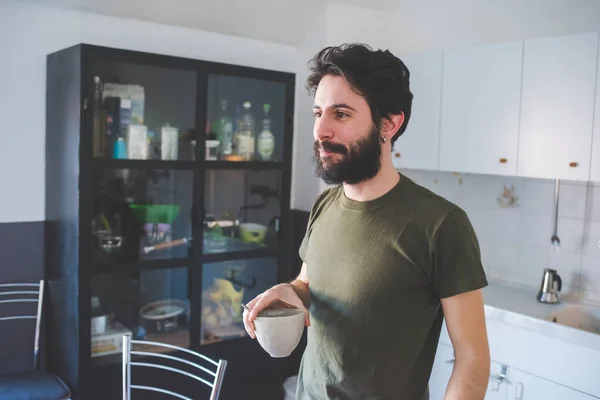 Young man spending morning at home having cup of coffee