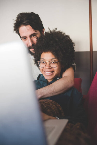 Young Multiethnic Couple Indoor Using Computer Sitting Couch Stock Picture