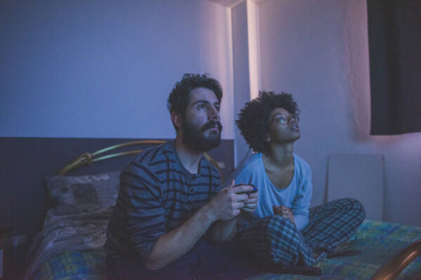 Young Multiethnic Couple Bedroom Playing Videogame Royalty Free Stock Photos