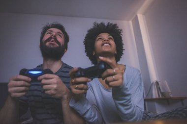 Genç çok ırklı çift yatak odası video oyunu oynuyor