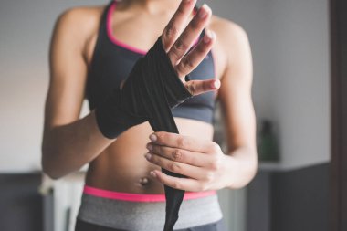 Evde çalışan çok ırklı genç bir kadın boks kaseti paketliyor. 