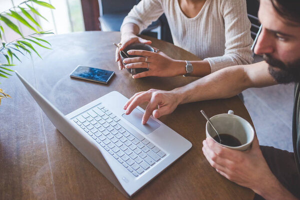 Young Multiethnic Couple Indoor Watching Streaming Computer Having Coffee Royalty Free Stock Images