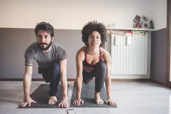 Pareja Multiétnica Casa Practicando Deporte Haciendo Fitness Yoga Imágenes de stock libres de derechos