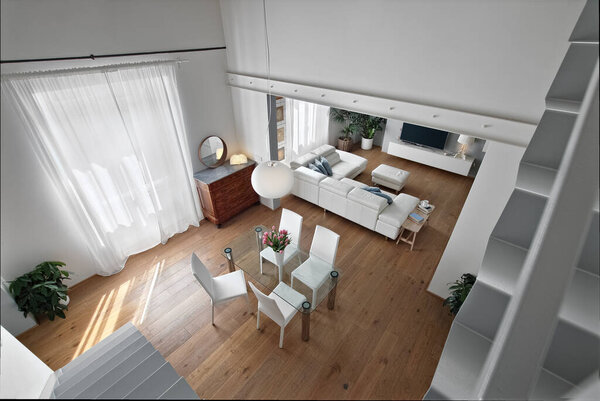 вид сверху на современную гостиную на переднем плане столовая со стеклянным столом и стульями, а на заднем плане можно увидеть переговорную зону с большим кожаным диваном