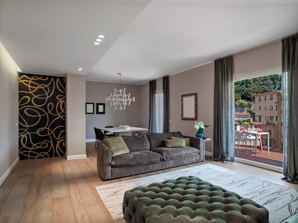 интерьер современной гостиной с диваном и деревянным полом с видом на террасу