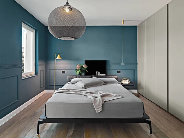 现代卧房内饰在前排的床上 地板是用木地板做的 免版税图库图片
