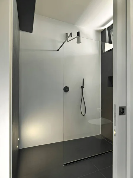 现代化浴室内有玻璃门的大型淋浴间的特写镜头 图库图片
