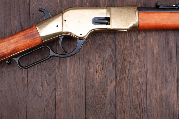 Old west gun. Lever-action repeating rifle on wooden table.