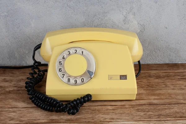 Vintage Gele Draaibare Wijzerplaat Telefoon Houten Tafel Voorkant Grijs Beton — Stockfoto