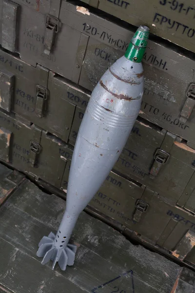 120 mm caliber mortar shell on army green crate. Text in russian - type of ammunition, projectile caliber, projectile type, number of pieces and weight.