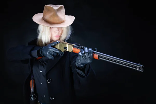 Old west girl in white hat with rifle on black background