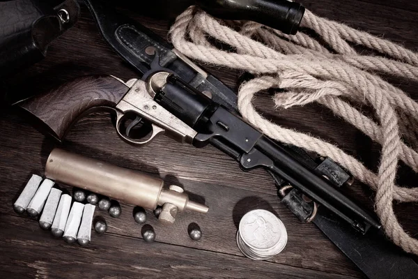Old West gun - Percussion Army Revolver with paper cartridges, bullets, powder flask and holster on wooden table