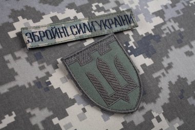 KYIV, UKRAINE - October 6, 2022. Russian invasion in Ukraine 2022. Territorial Defence Forces of Ukraine uniform insignia badge on camouflaged uniform background. clipart