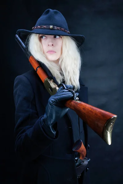 Siyah Şapkalı Siyah Arka Planda Silahlı Yaşlı Sarışın Kız — Stok fotoğraf