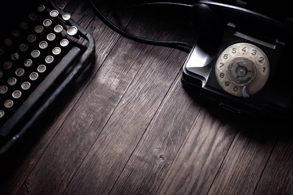 木制桌子上有老式打字机的老式复古旋转电话 — 图库照片