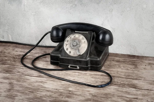 Ρετρό Μαύρο Περιστροφικό Τηλέφωνο Ξύλινο Τραπέζι Μπροστά Γκρι Φόντο Τσιμέντο — Φωτογραφία Αρχείου