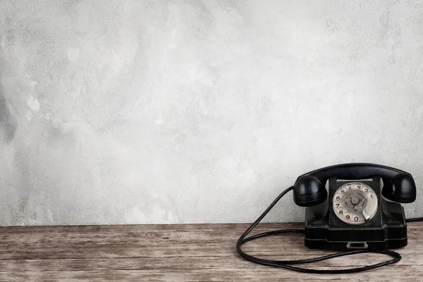 Μαύρο Περιστροφικό Τηλέφωνο Ξύλινο Τραπέζι Στο Μπροστινό Γκρι Φόντο Μπετόν — Φωτογραφία Αρχείου