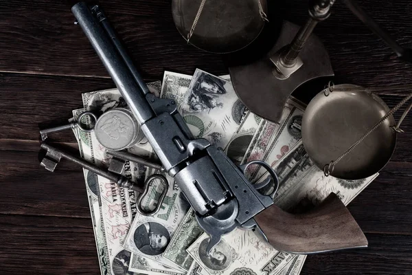 旧西柯尔特左轮手枪 美国钞票和银质证书 附有银元硬币和木制桌子背景的青铜传统天平 — 图库照片