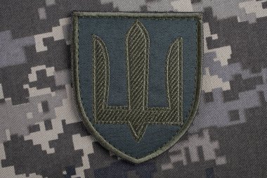 KYIV, UKRAINE - October 5, 2022. Russian invasion in Ukraine 2022. Ukraine Army uniform shoulder sleeve insignia badge on camouflaged uniform background. clipart