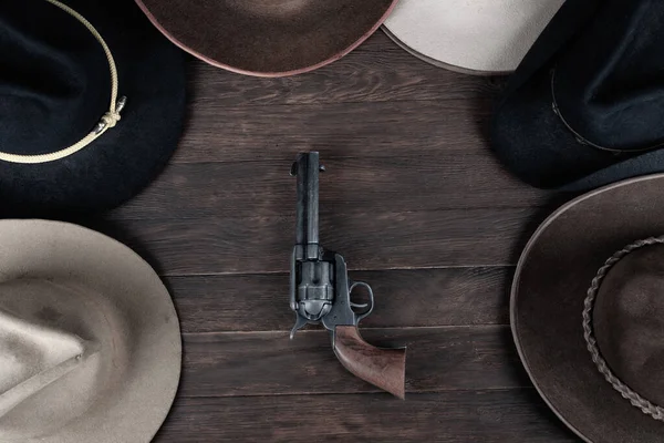 木制桌子上挂着旧西帽的枪 顶部视图 — 图库照片