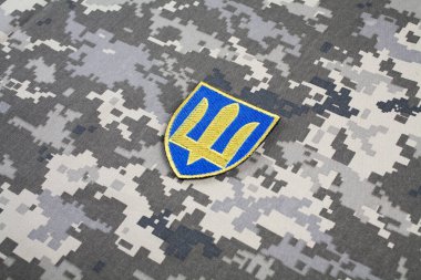 KYIV, UKRAINE - October 5, 2022. Russian invasion in Ukraine 2022. Ukraine Army Commander in Chief of the Armed Forces of Ukraine uniform shoulder sleeve insignia badge on camouflaged uniform background. clipart