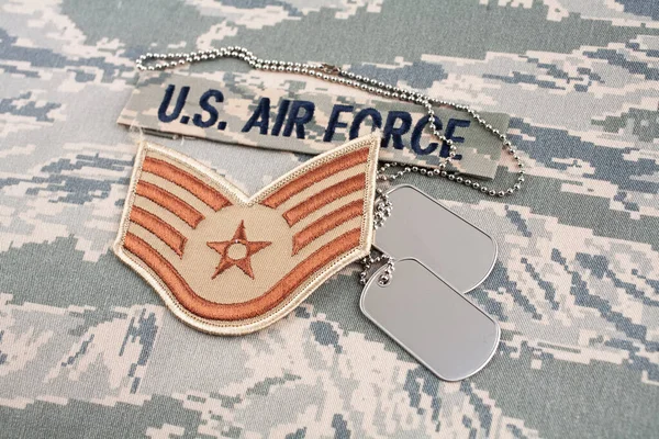 US AIR FORCE branch tape and Staff Sergeant rank patch and dog tags on digital tiger-stripe pattern Airman Battle Uniform background