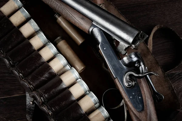 stock image 12-gauge break-action smooth-bored shotgun with paper cases on wooden table.