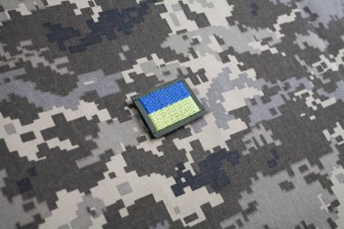 KYIV, UKRAINE - October 5, 2022. Russian invasion in Ukraine 2022. Ukraine Army Flag Patch uniform shoulder sleeve insignia badge on camouflaged uniform background. clipart
