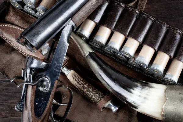 stock image Antique 12 gauge break action smooth bored double barreled shotgun with paper cases on wooden table.