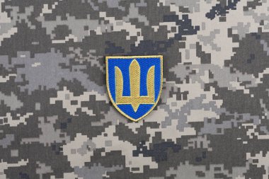 KYIV, UKRAINE - October 5, 2022. Russian invasion in Ukraine 2022. Ukraine Army Commander in Chief of the Armed Forces of Ukraine uniform shoulder sleeve insignia badge on camouflaged uniform background. clipart
