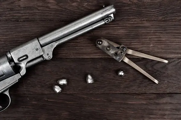 Stock image Antique old west bullet mold with bullets for revolver. Isolated on white background.