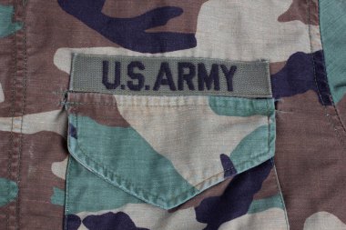 US ARMY branch tape on woodland camouflage uniform background clipart