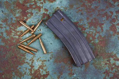 Ammunition with magazine on rusty metal background clipart