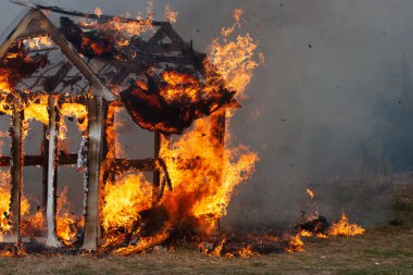 burning fire in a small wooden house in the village clipart