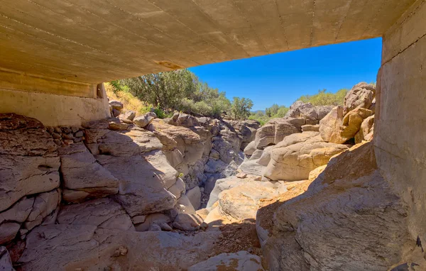 View of a shallow canyon near Perkinsville Arizona from beneath a bridge. The canyon has no official name on the map but I call it Gray Stone Canyon because of the gray colored rock that lines its walls and bottom.
