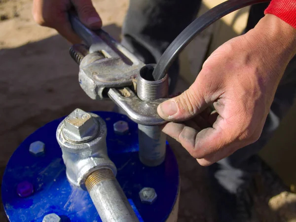 stock image A connection being made between the pipe of a Well Pump and the electrical cable to power it.