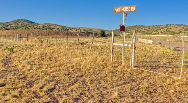 Prescott Ulusal Ormanı sınırında ve Chino Valley Arizona kasabasında Orman Hizmetleri Yolu 70 'in üzerinde bulunan Half Horse Yolu. Çit, ulusal ormanın ve kasabanın sınırını gösteriyor. Kapıda Pitrat yazıyor.