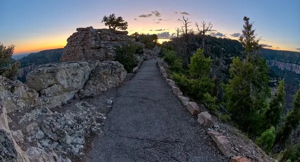 The paved pathway between Bright Angel Point and the visitor center at Grand Canyon North Rim Arizona at twilight.