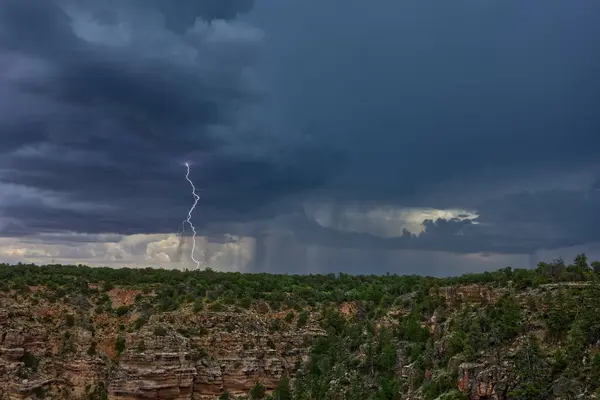 An Arizona Monsoon storm approaching Grand Canyon South Rim. This lightning strike was captured near the Desert View Point viewed from Navajo Point.