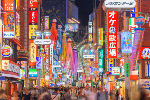 TOKYO, JAPAN - AUGUST 4, 2015: Crowds throng Shibuya Central-Gai at night. The street is a main hub for youth culture.