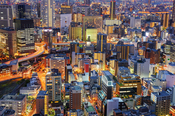 Osaka, Japan cityscape with dense architecture in the Umeda District at night.