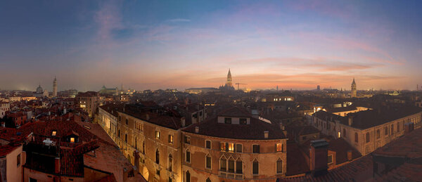 Venice, Italy rooftop skyline and historic landmarks at dusk.