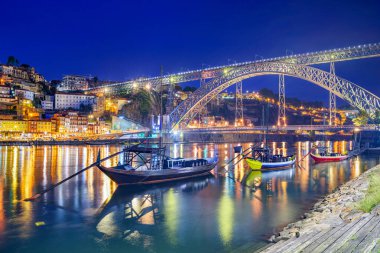 Porto, Portekiz 'in eski kasabası Douro Nehri üzerinde geceleri haham tekneleriyle ufuk çizgisi.