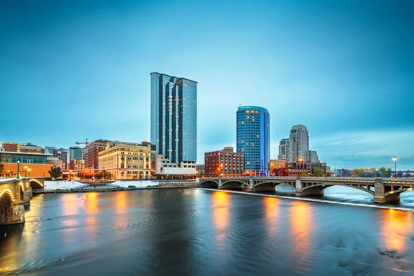 Grand Rapids, Michigan, USA downtown skyline on the Grand River at dusk.