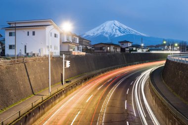 Mt. Fuji, Japonya alacakaranlıkta mahalleler ve otoyollar üzerinde yükseliyor..