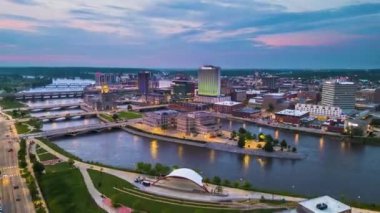 Cedar Rapids, Iowa, ABD Cedar Nehri üzerindeki şehir manzarası alacakaranlıkta.