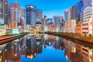 Osaka, Japonya Finans Bölgesi Skyline Okawa Nehri üzerinde mavi saatte.