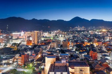 Beppu, kyushu, Japon şehri mavi saatte dağlarla gökyüzü..