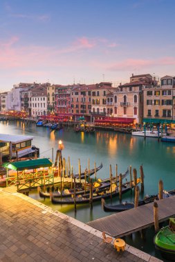 Venice, Italy overlooking boats and gondolas in the Grand Canal at dusk.