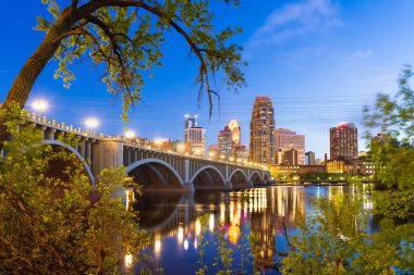 Minneapolis, Minnesota, ABD şehir merkezi Mississippi Nehri üzerinde mavi saatte gökyüzü..